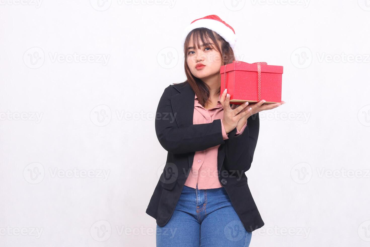 schön asiatisch Mädchen im passen lächelnd mit Santa claus Hut posieren mit Weihnachten Geschenk Box Geschenk und Heben Box und küssen auf Weiß Hintergrund zum Förderung, Werbung, Banner, Plakatwand foto