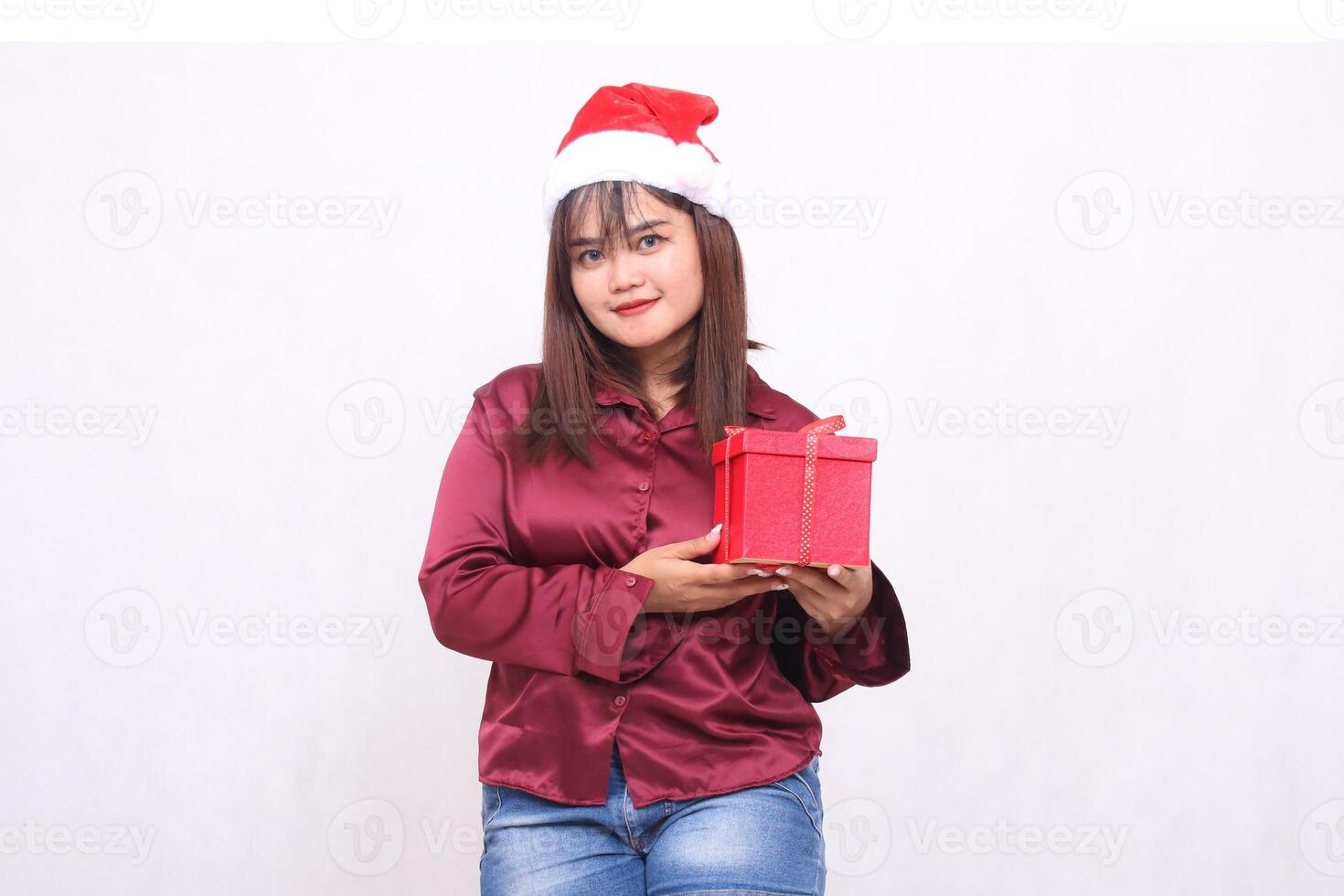 Foto Porträt von schön lächelnd asiatisch Mädchen im ihr 20er Jahre Tragen verpackt Geschenke beim Weihnachten Santa claus Hut modern glänzend rot Hemd Outfit gesehen auf Weiß Hintergrund zum Beförderung und Werbung