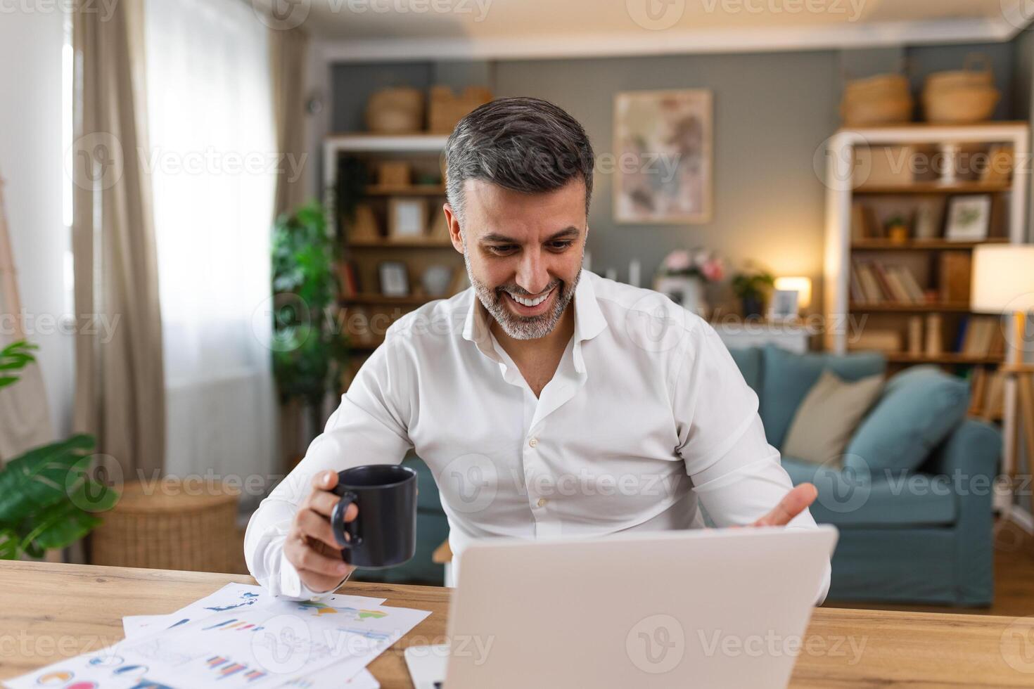 Schuss von ein Geschäftsmann auf ein Anruf während Sitzung beim seine Schreibtisch. abgeschnitten Schuss von ein attraktiv Mann mit seine Laptop zu machen ein Anruf beim Zuhause foto