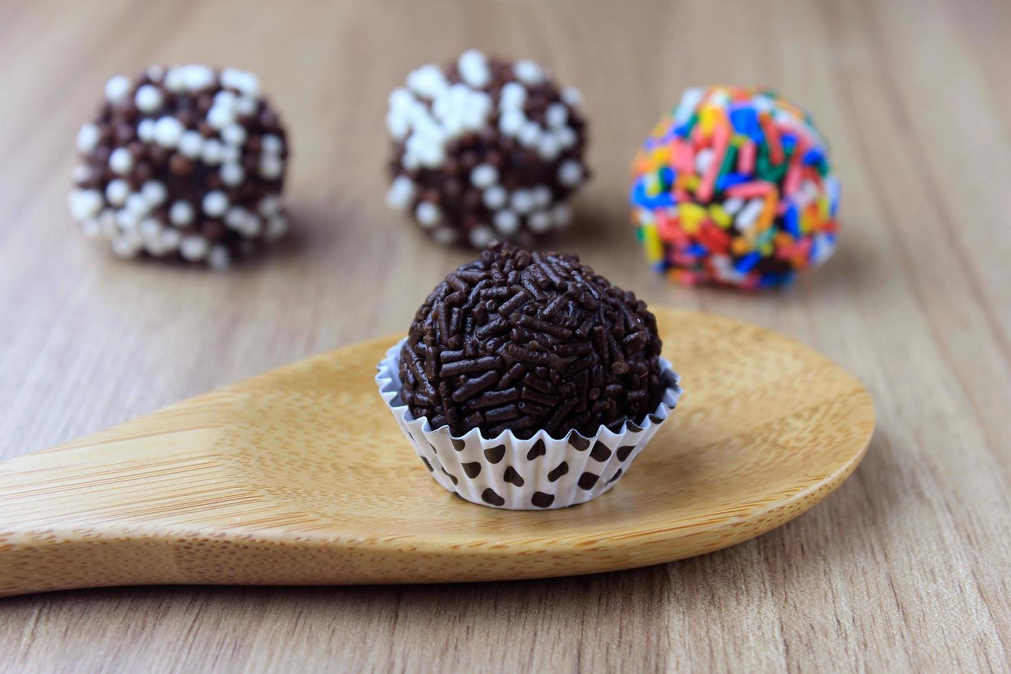 Brigadeiro, Brigadegeneral, süße Schokolade typisch für die brasilianische Küche mit Partikeln bedeckt, in einem hölzernen Hintergrund. foto