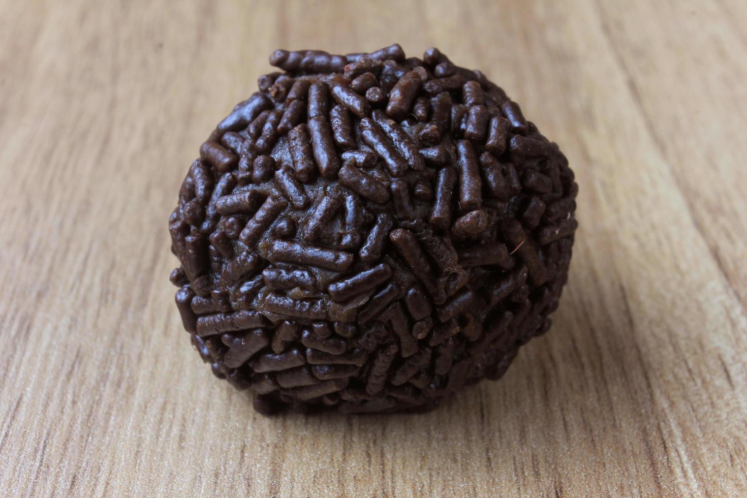 Brigadeiro, Brigadegeneral, süße Schokolade typisch für die brasilianische Küche mit Partikeln bedeckt, in einem hölzernen Hintergrund. foto