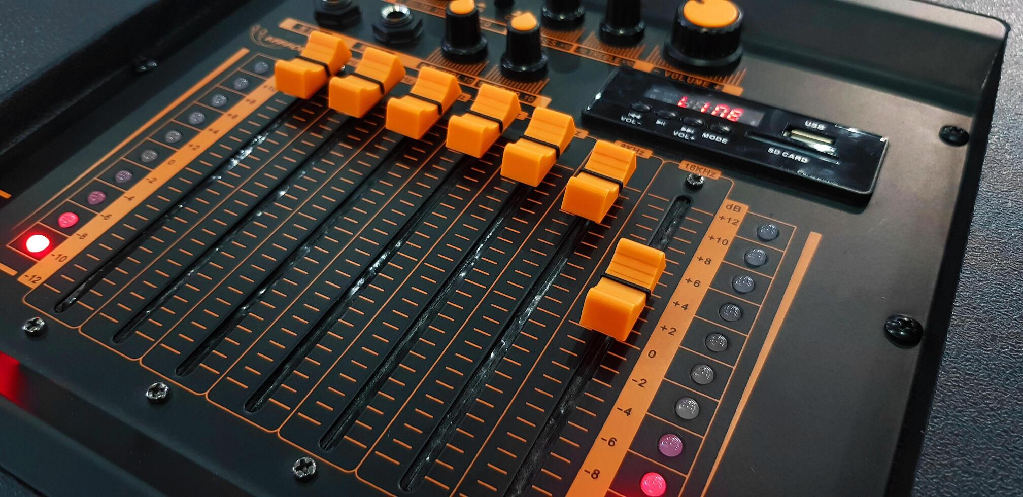 schließen oben Orange Taste von Klang Rührgerät Panel Ausrüstung zum Mischen oder Steuerung Audio- System mit selektiv Fokus Technik. Technologie, Werkzeug und Digital Gerät Konzept. foto