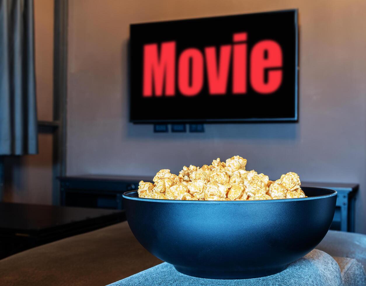 Popcorn im schwarz Schüssel mit Fernsehen rot Text Film auf Anzeige Fernsehen im Leben Zimmer foto