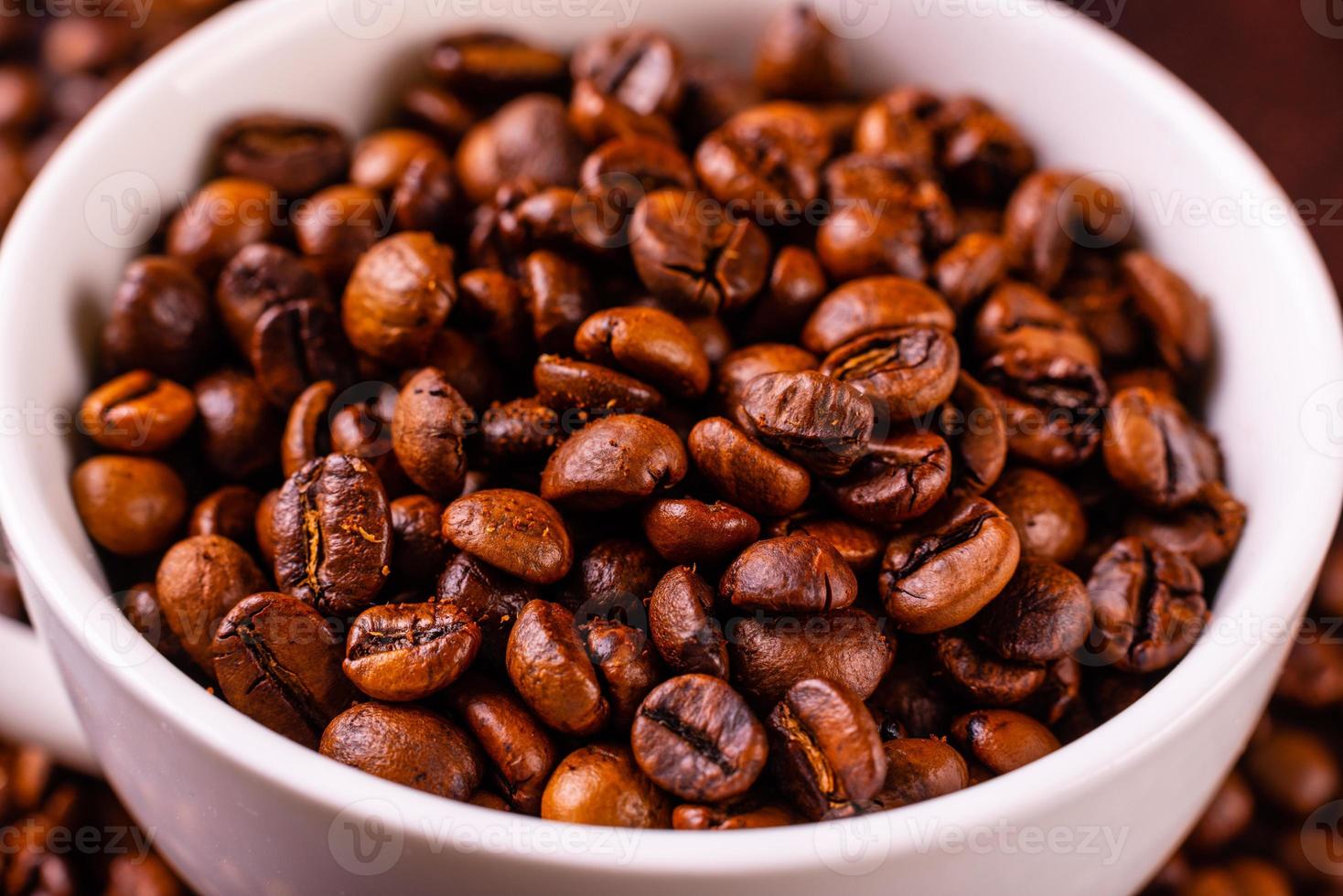 Samen von duftendem Kaffee auf dunklem Betonhintergrund foto