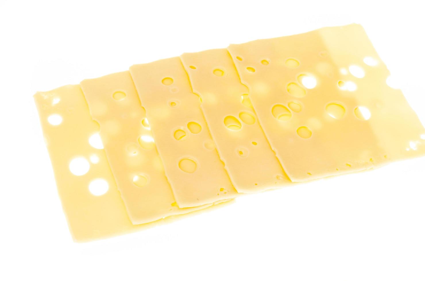 Käsescheiben mit Löchern auf weißem Hintergrund foto