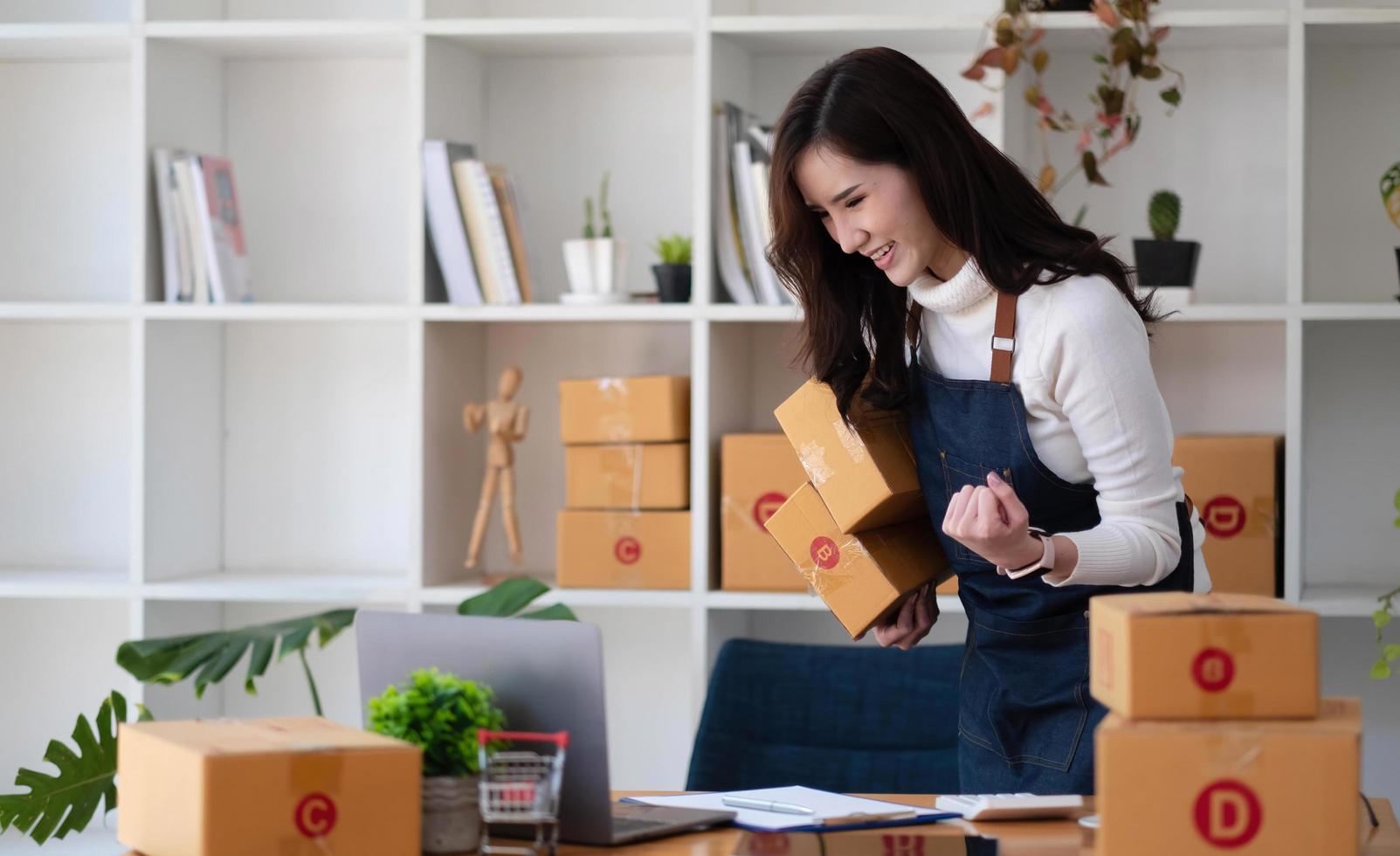 Start Kleinunternehmer KMU freiberuflich, Porträt junge Frau, die im Home Office arbeitet, Box, Smartphone, Laptop, Online, Marketing, Verpackung, Lieferung, KMU, E-Commerce-Konzept foto