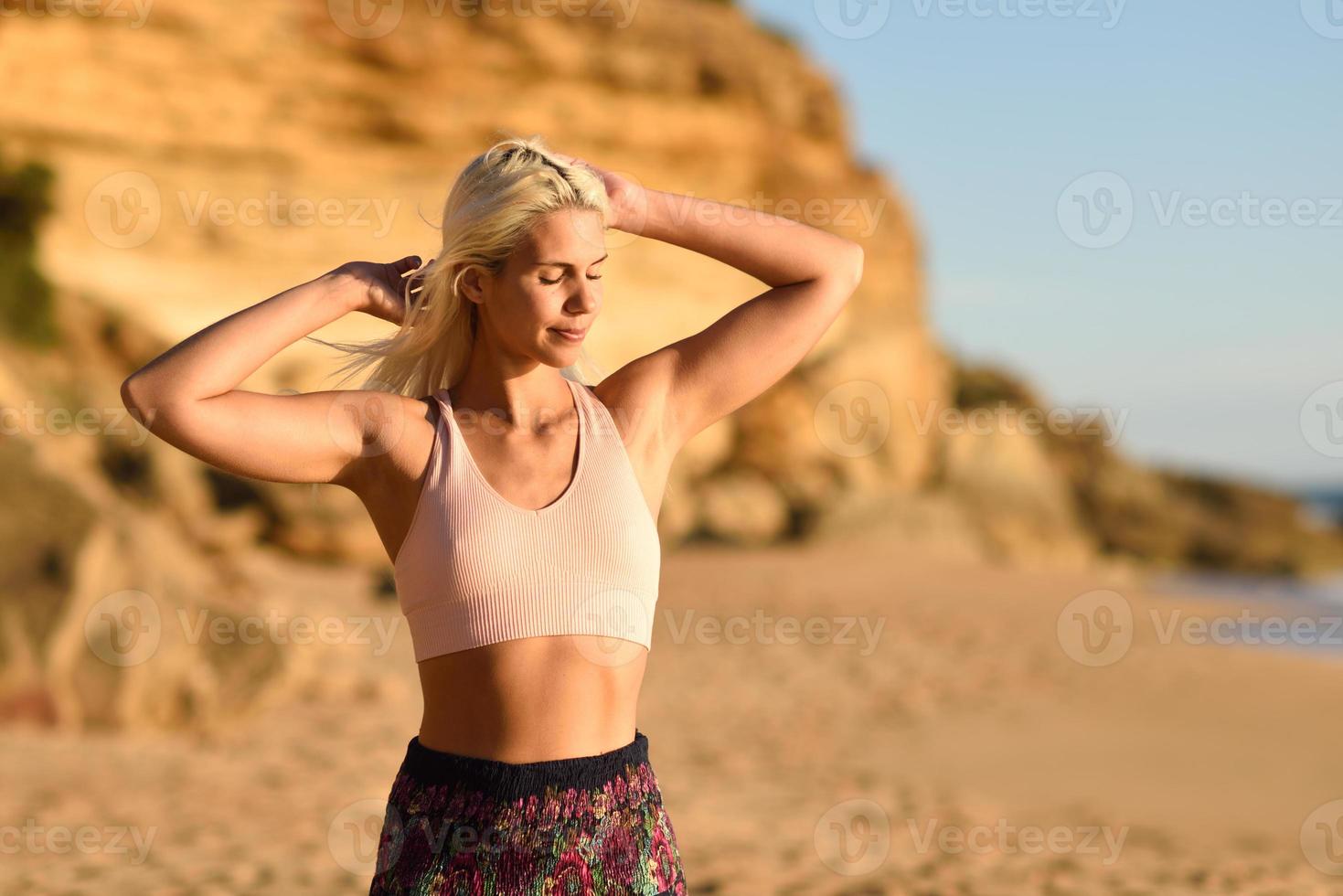 Frau genießt den Sonnenuntergang an einem schönen Strand foto