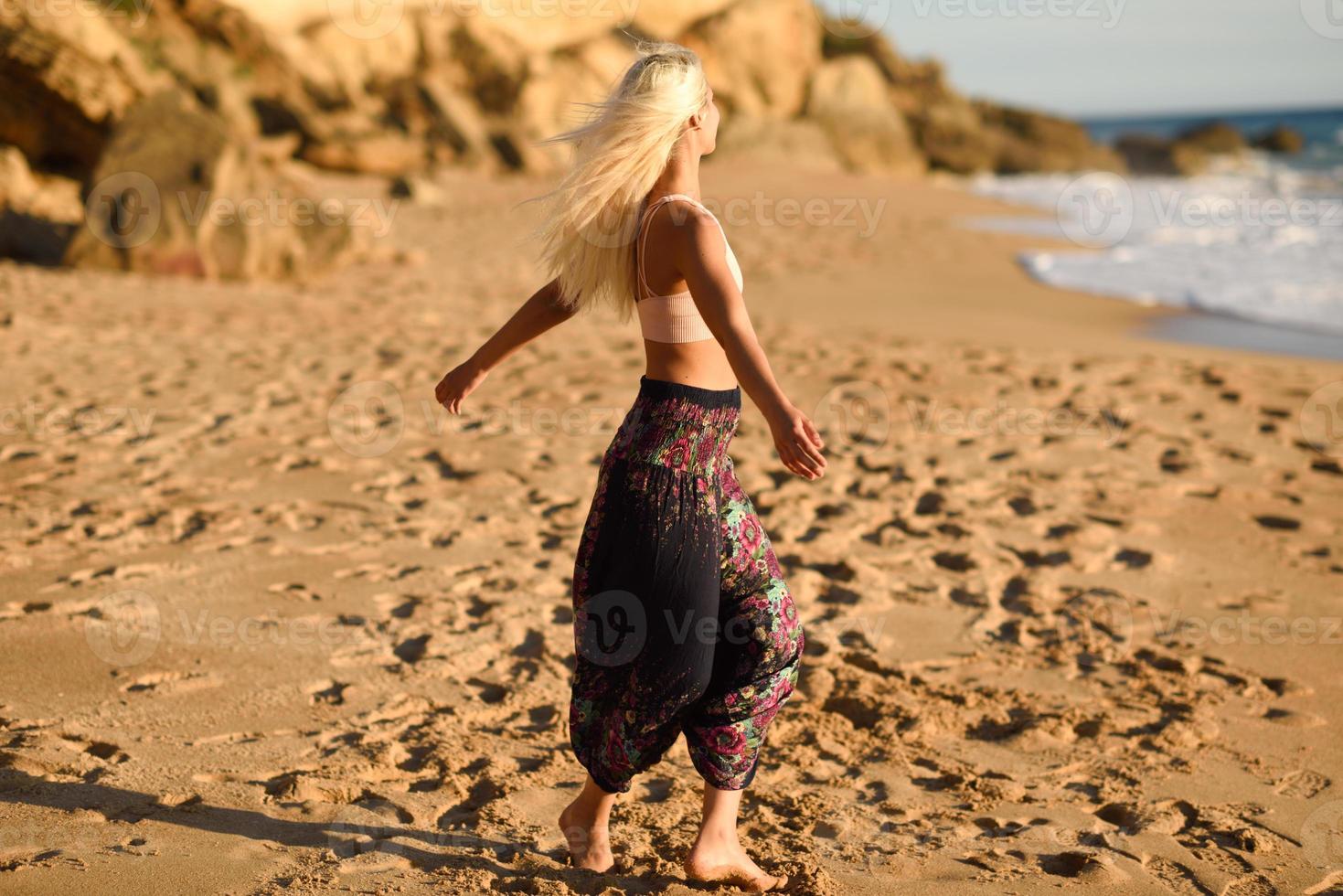 Frau genießt den Sonnenuntergang an einem schönen Strand foto