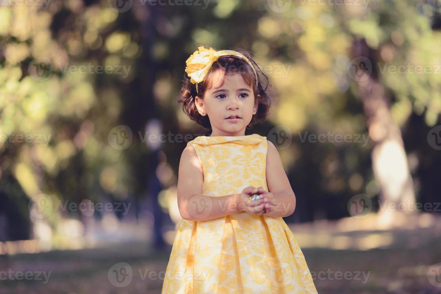 kleines Mädchen, das im Park läuft und spielt foto