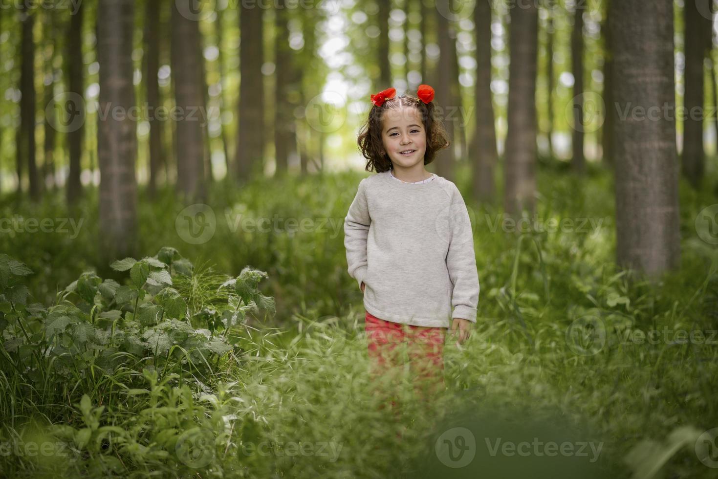 süßes kleines Mädchen, das Spaß in einem Pappelwald hat foto