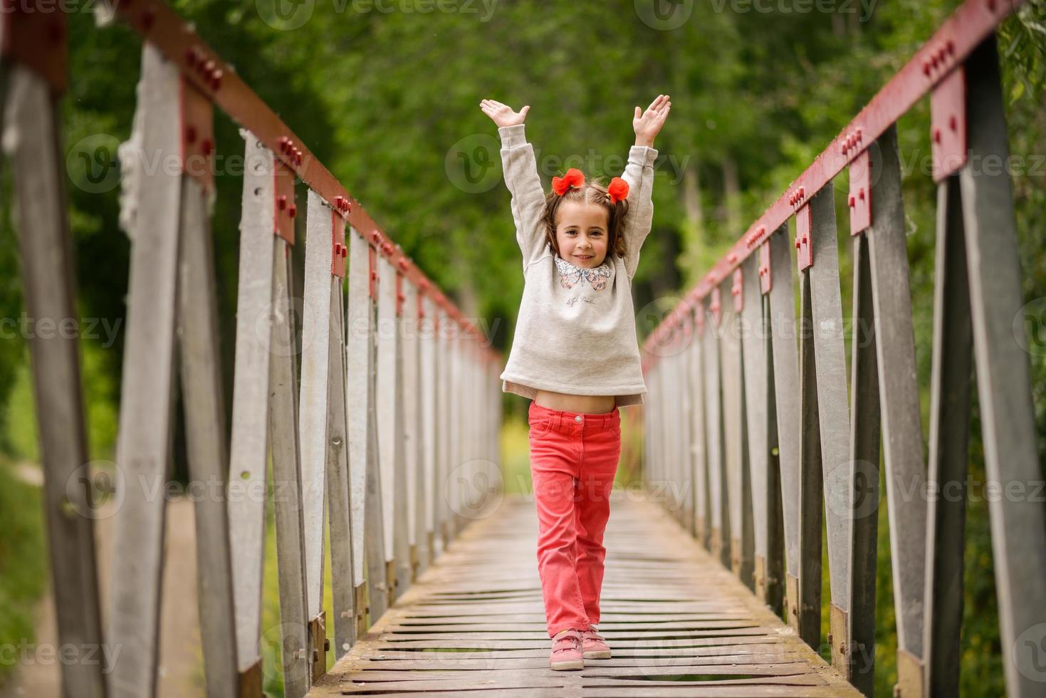 süßes kleines Mädchen, das Spaß in einer ländlichen Brücke hat foto