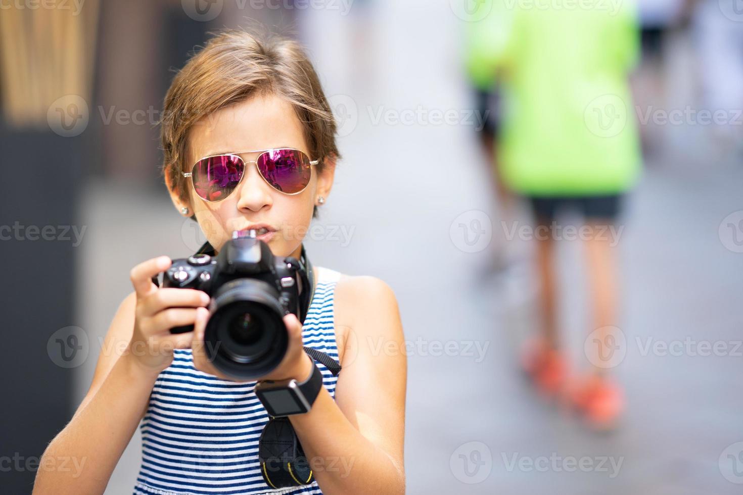 kleines Mädchen, das Foto mit DSLR-Kamera auf Stadtstraße macht