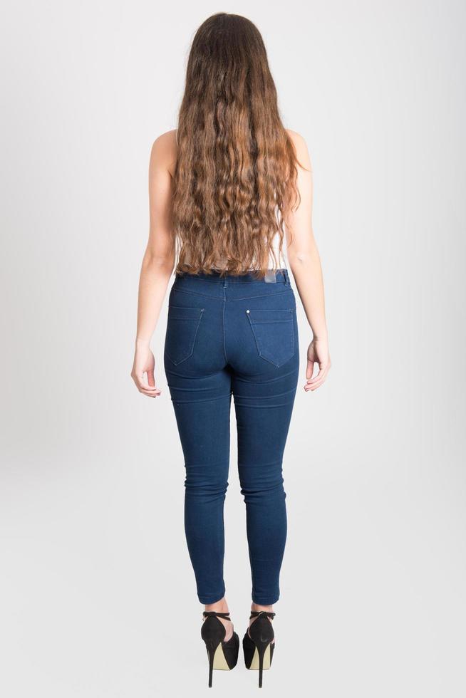 Frau mit langen Haaren in weißem T-Shirt und Blue Jeans foto