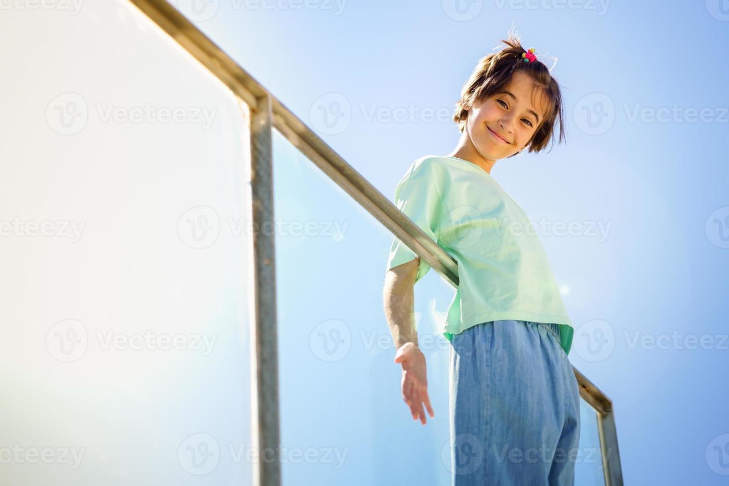9-jähriges Mädchen posiert glücklich auf einer Treppe foto