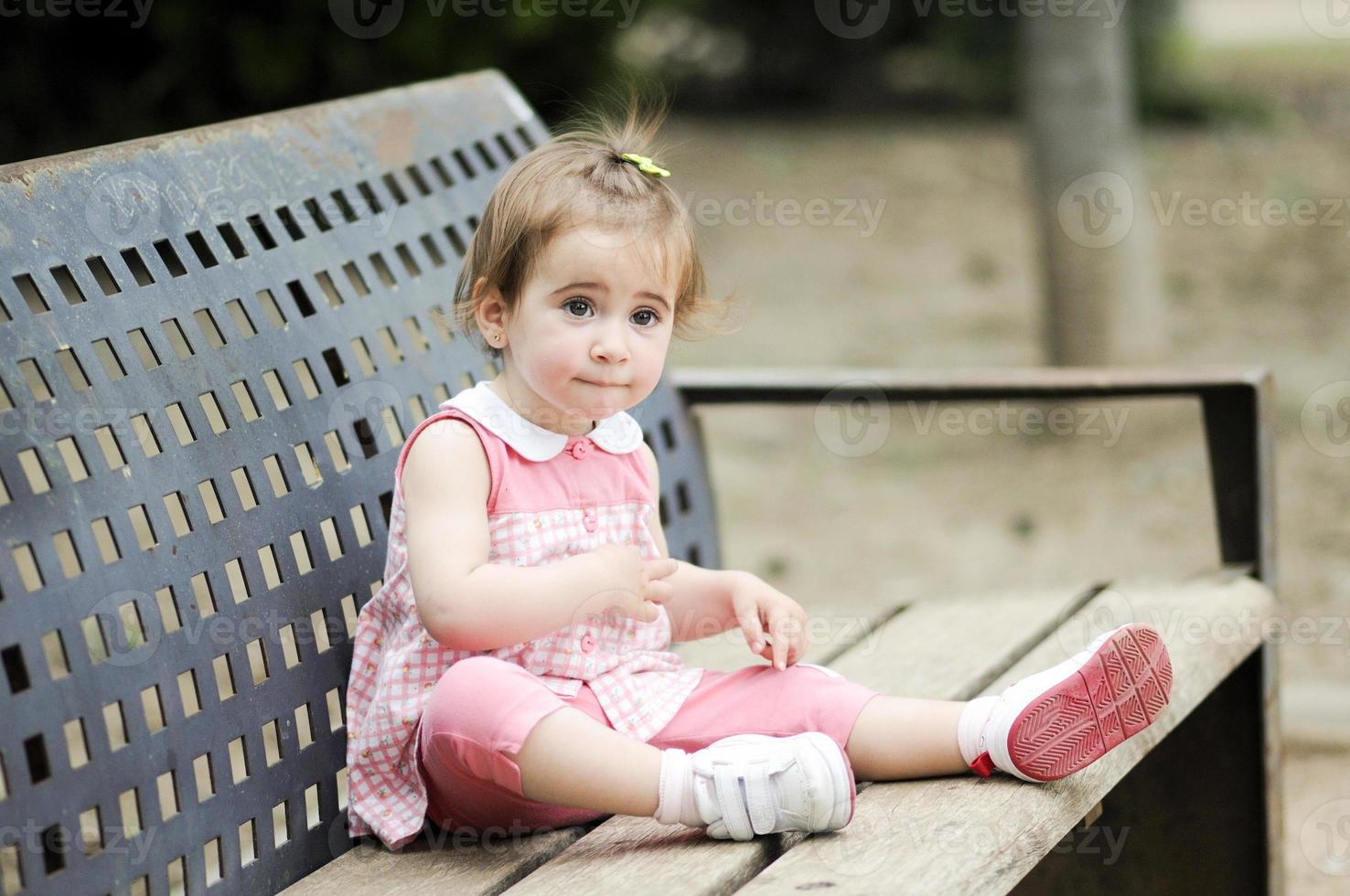 kleines Mädchen, das in einem Stadtpark spielt foto