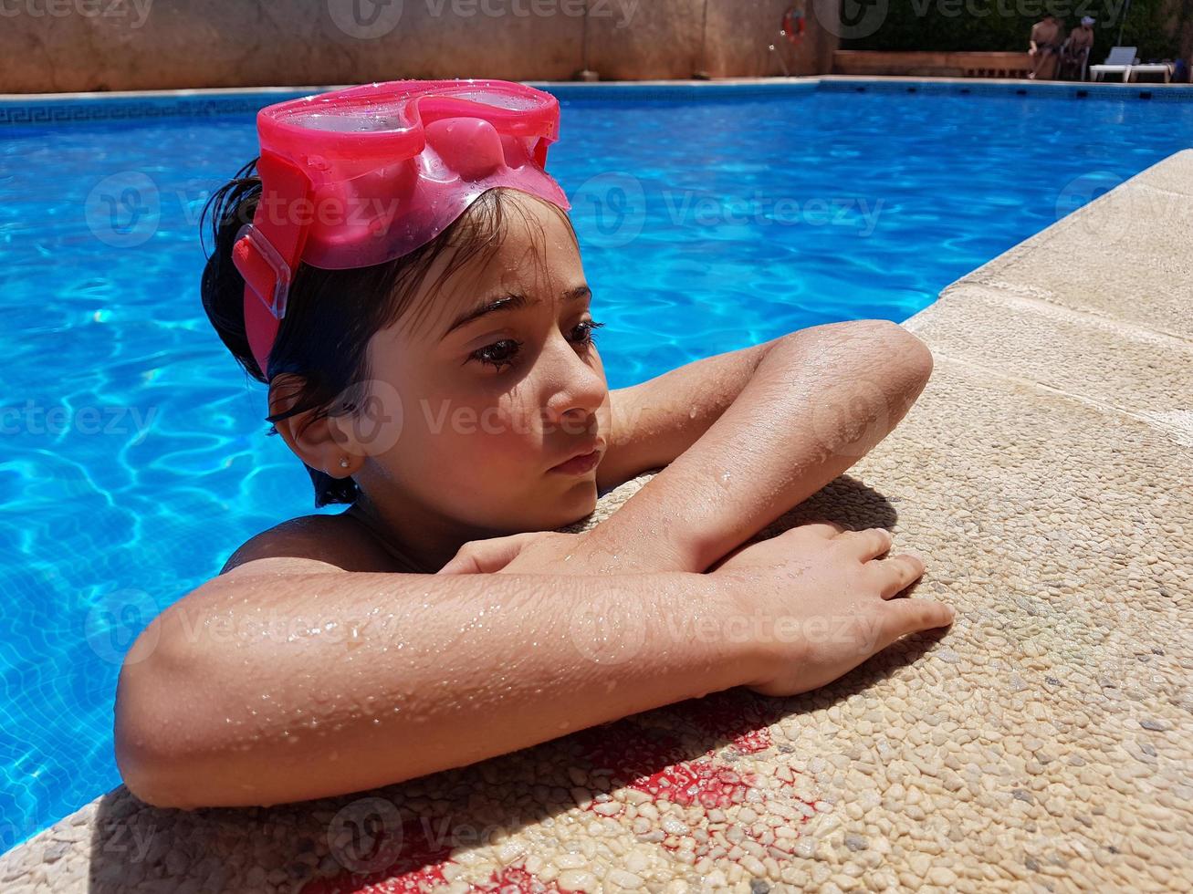 kleines Mädchen beim Baden in einem Pool mit Taucherbrille foto