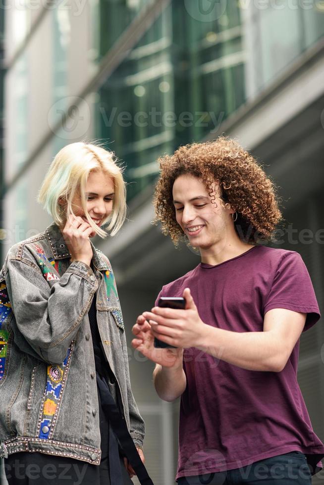 glückliches Paar mit Smartphone im städtischen Hintergrund. foto