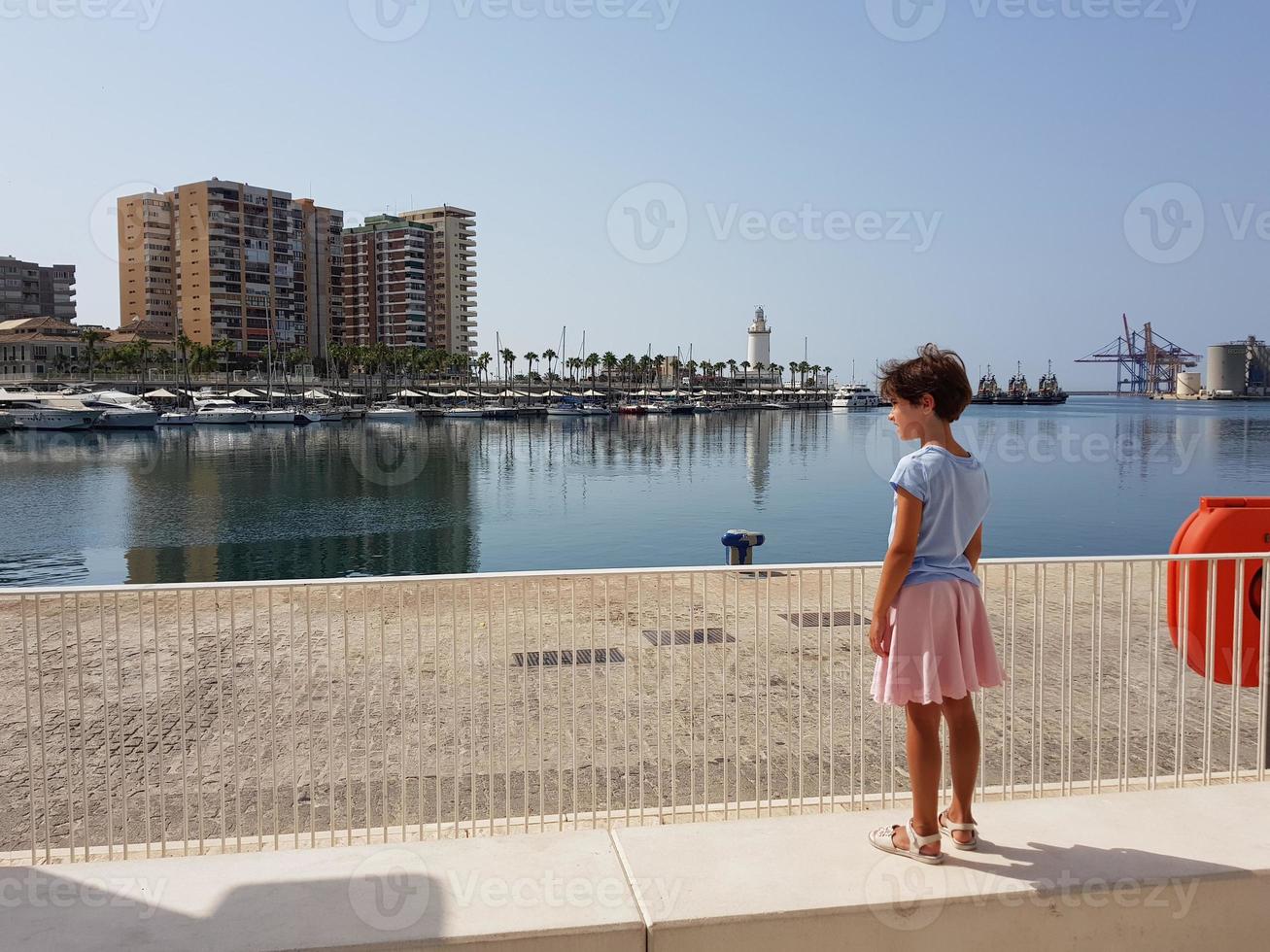 kleines Mädchen mit Blick auf den Hafen von Malaga foto