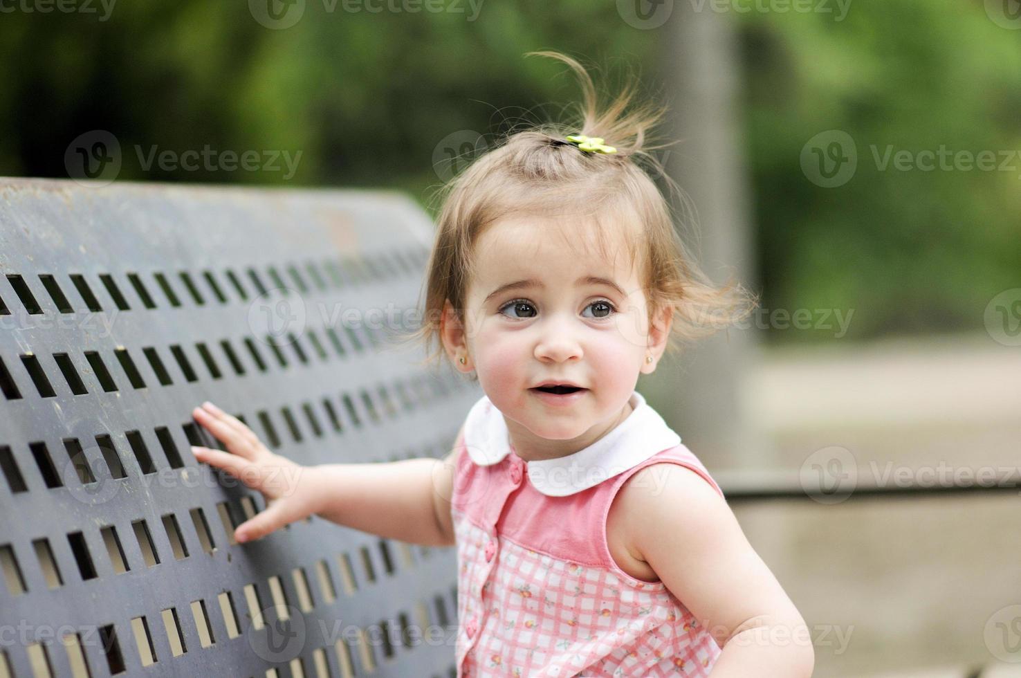 kleines Mädchen, das in einem Stadtpark spielt foto