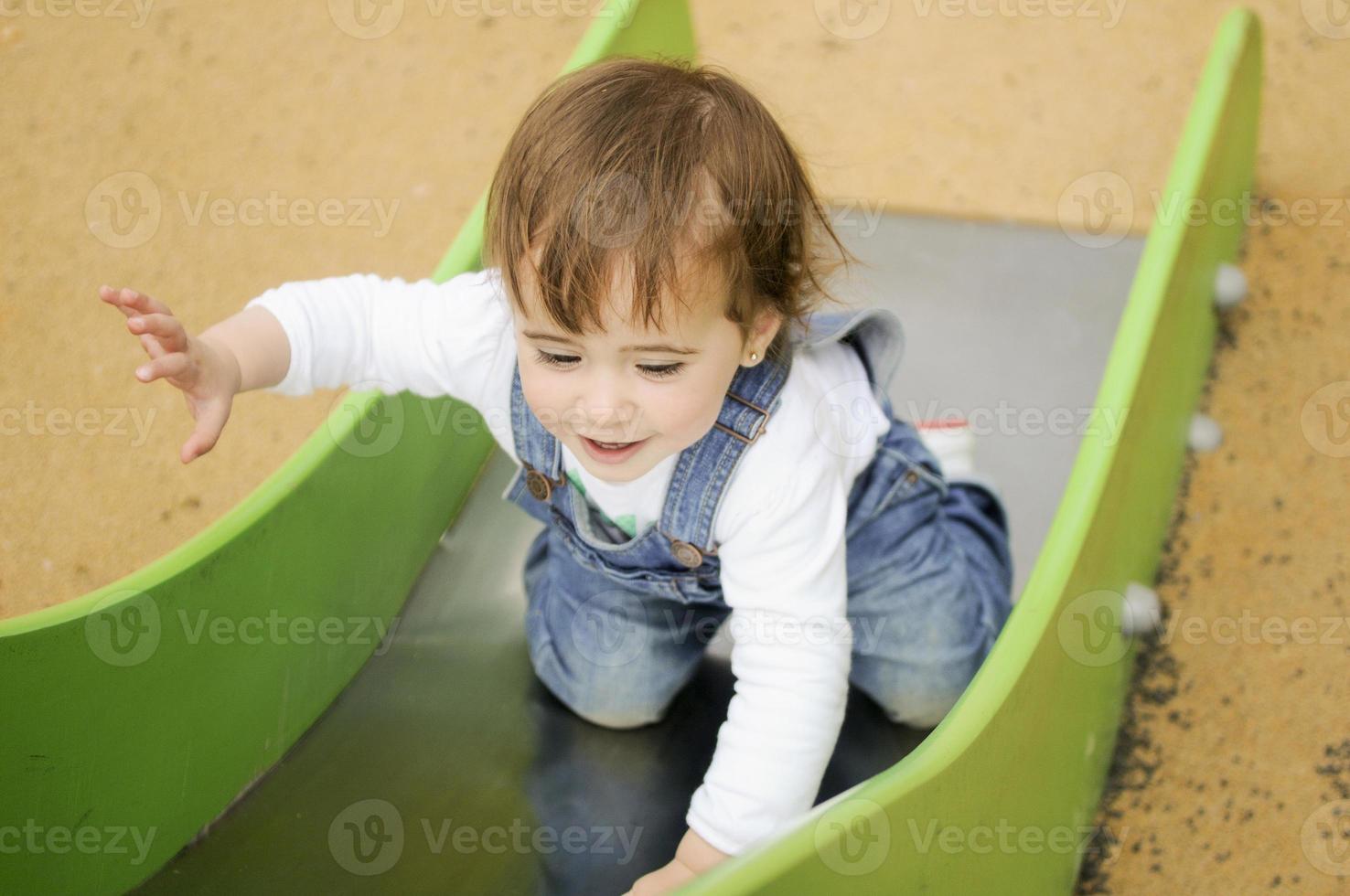 kleines Mädchen, das auf einem städtischen Spielplatz spielt. foto