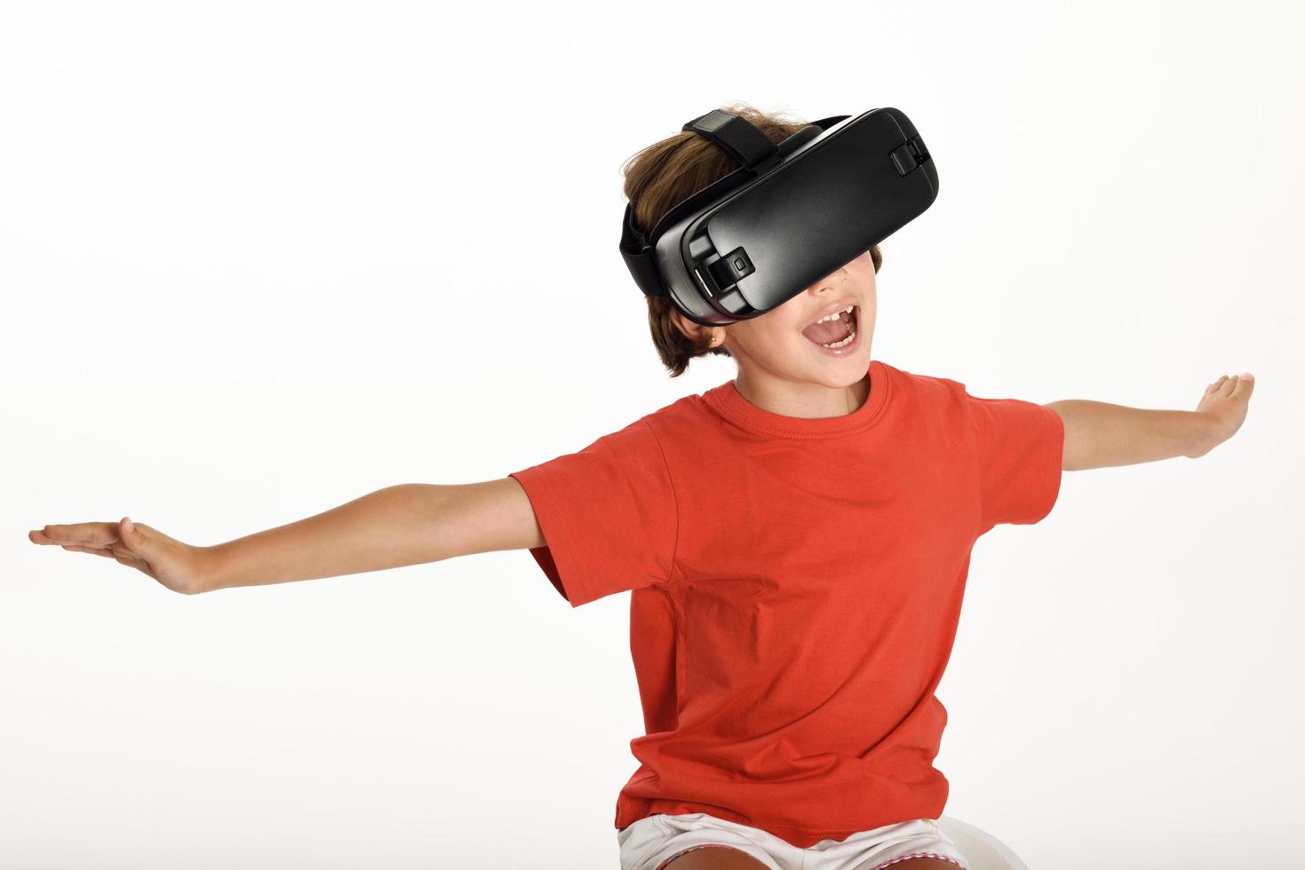 kleines Mädchen, das in eine VR-Brille schaut und mit den Händen gestikuliert. foto