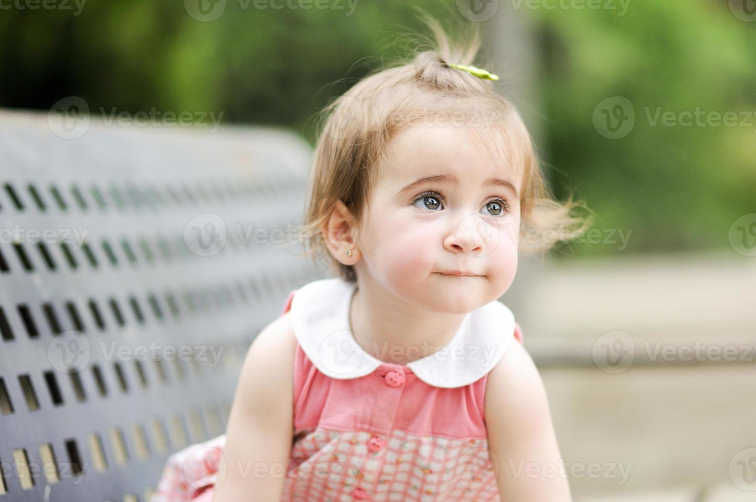 kleines Mädchen, das in einem Stadtpark spielt foto