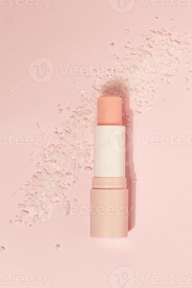 Lippensalzbalsampeeling mit Salz auf rosa Hintergrund, Kopierraum foto