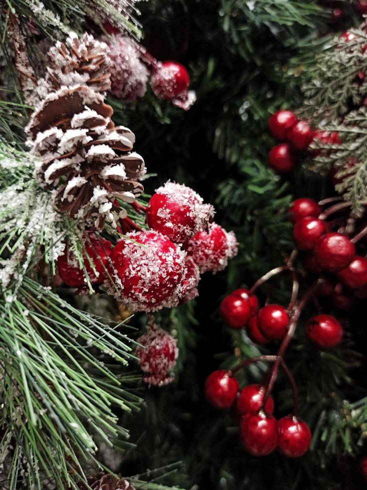 Weihnachtsbaum mit Dekorationen und roten Beeren. Weihnachtshintergrund foto