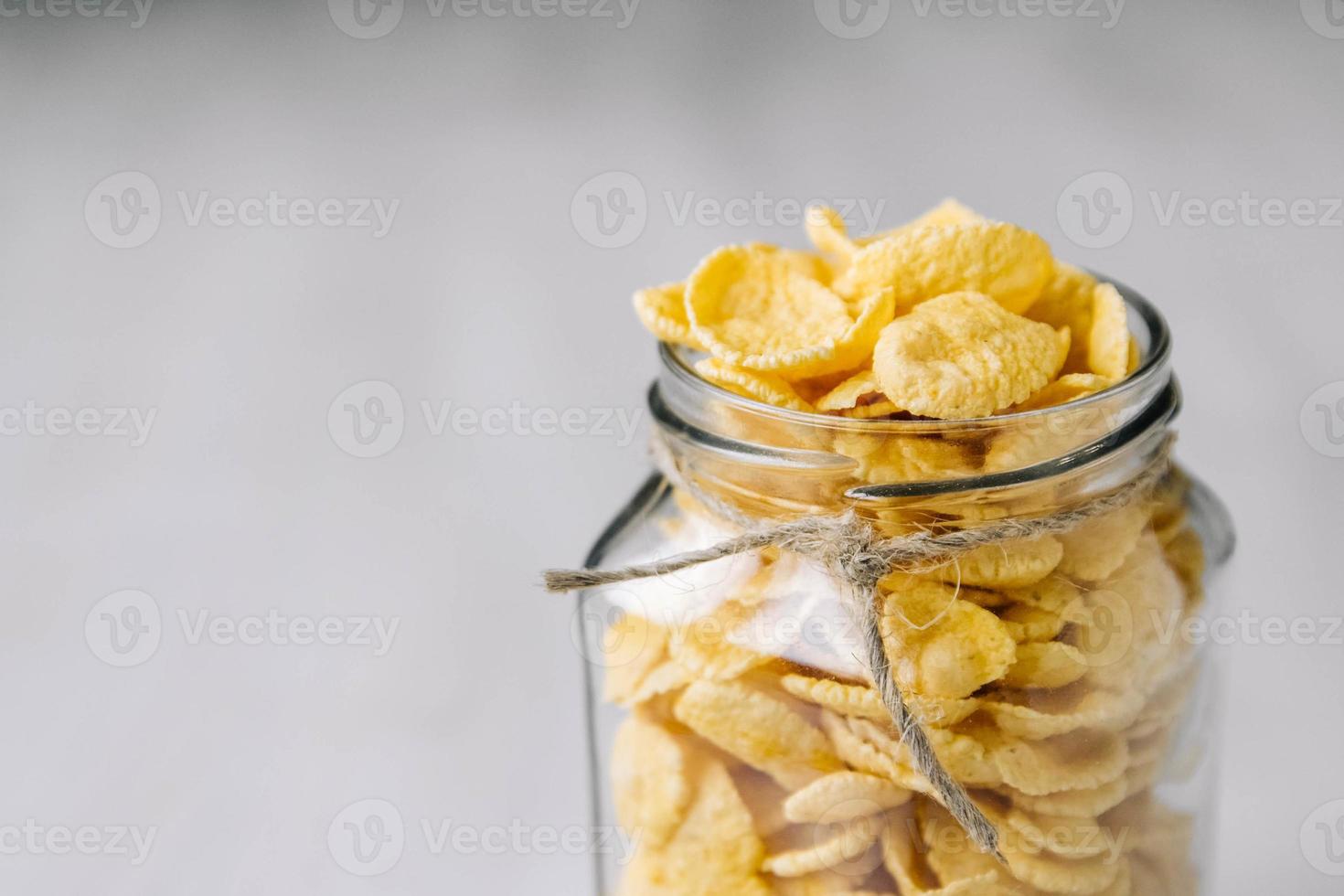 Cornflakes im Glas auf weißer Holzoberfläche foto