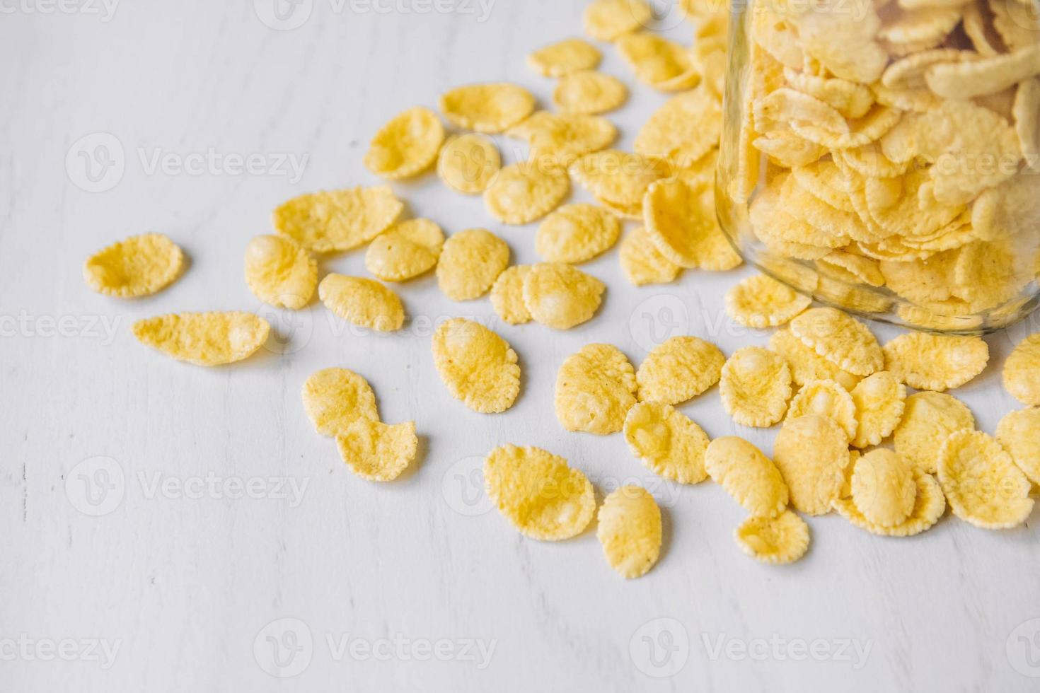 Cornflakes im Glas auf weißer Holzoberfläche foto