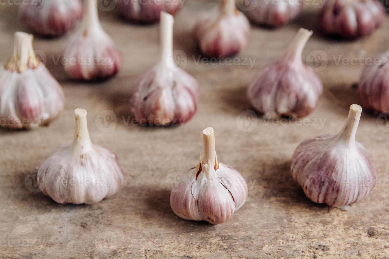 Knoblauch liegen in einer Reihe auf einem rustikalen Holzhintergrund foto