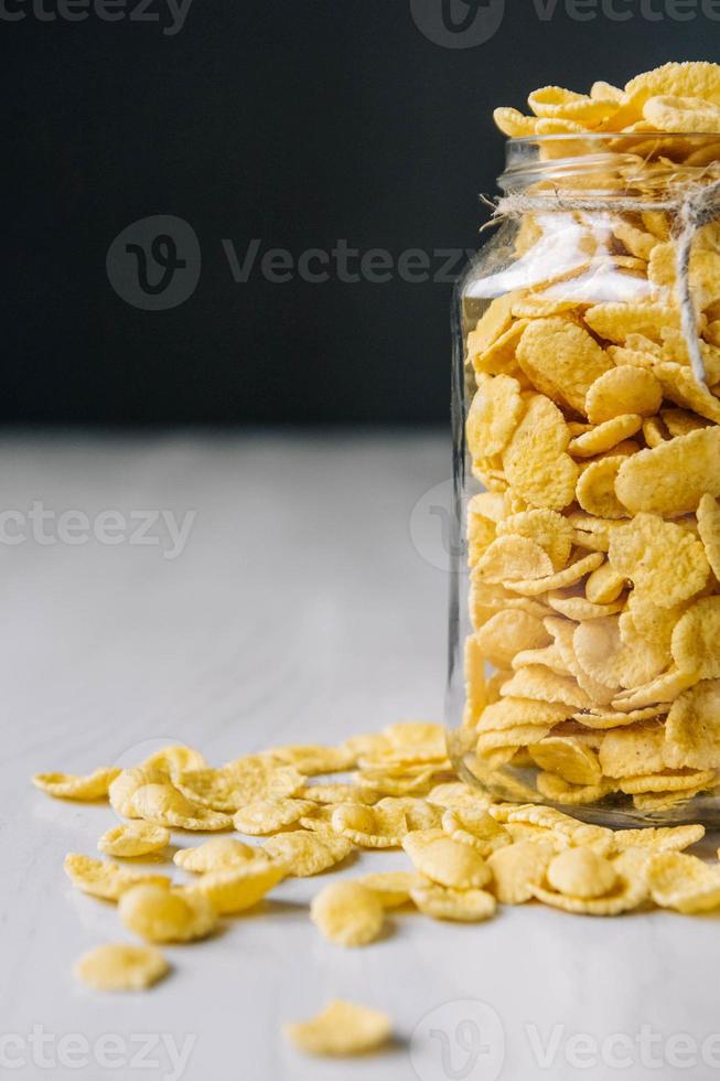 Cornflakes im Glas auf weißer Holzoberfläche foto