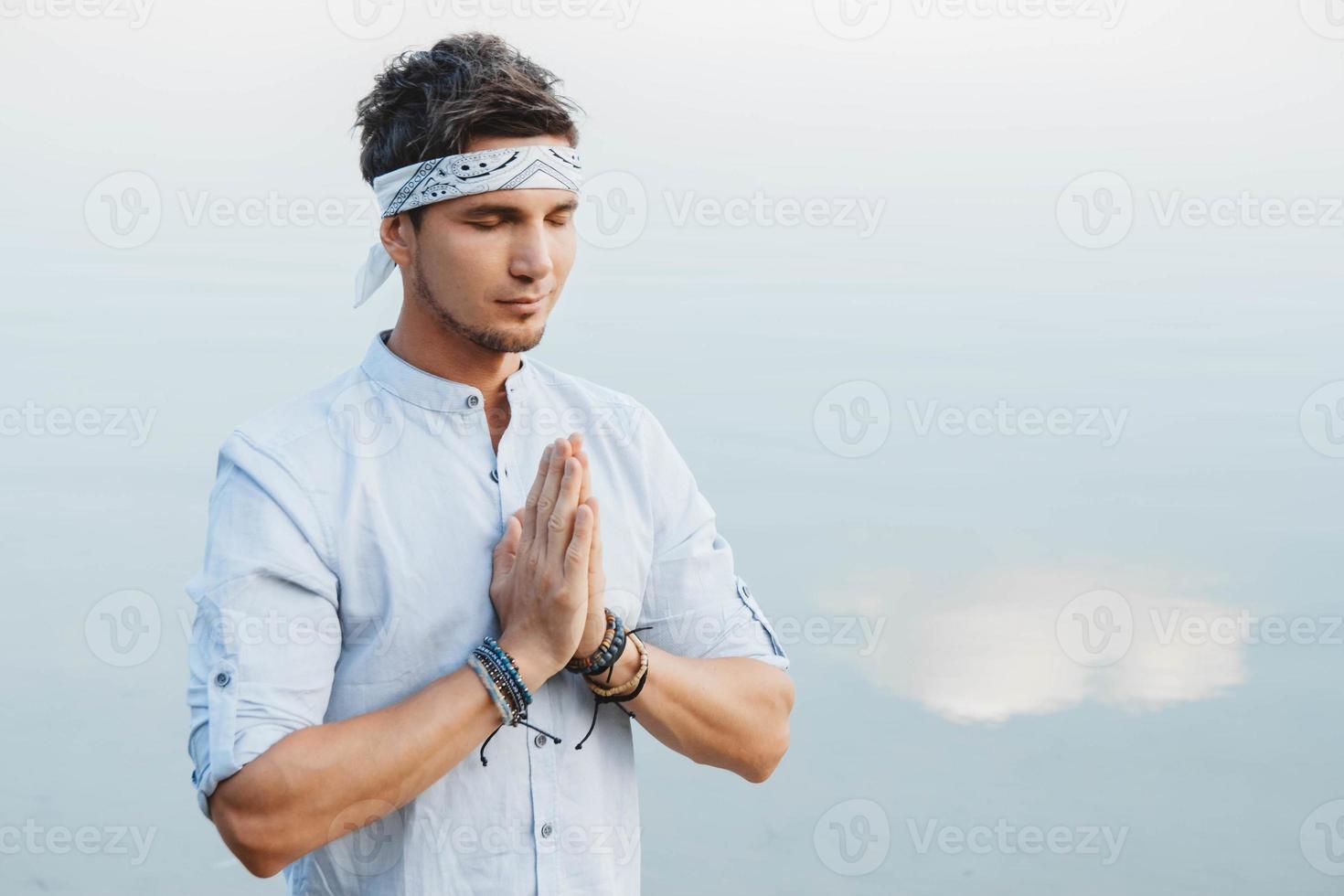 Mann hält Händchen im Gebet im Hintergrund Wasserreflex des blauen Himmels foto