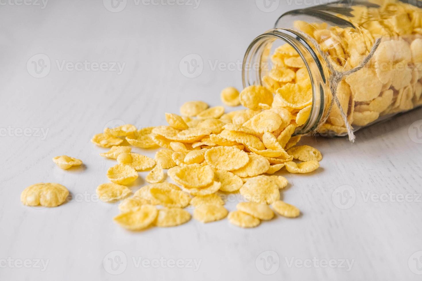 Cornflakes im Glas auf weißer Holzoberfläche foto