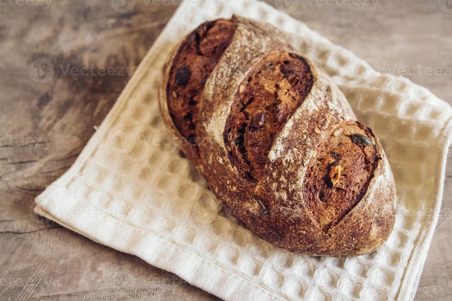 braunes frisches Brot mit Samen auf altem Holzhintergrund foto