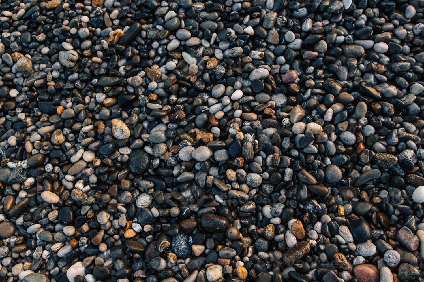 Kiesmuster aus nassen farbigen Steinen. abstrakter Naturkiesel Hintergrund foto