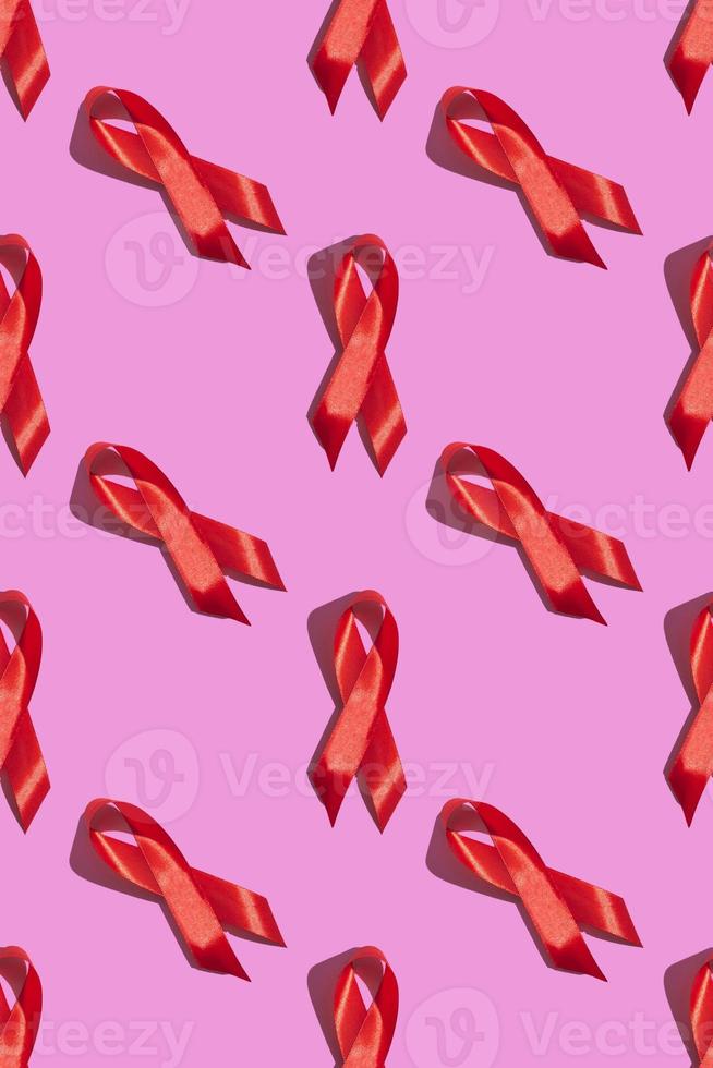 Internationaler Aids-Tag. rotes Band mit einem harten Schatten auf rosa Hintergrund. hilft Bewusstsein Konzept. vertikal. Muster foto