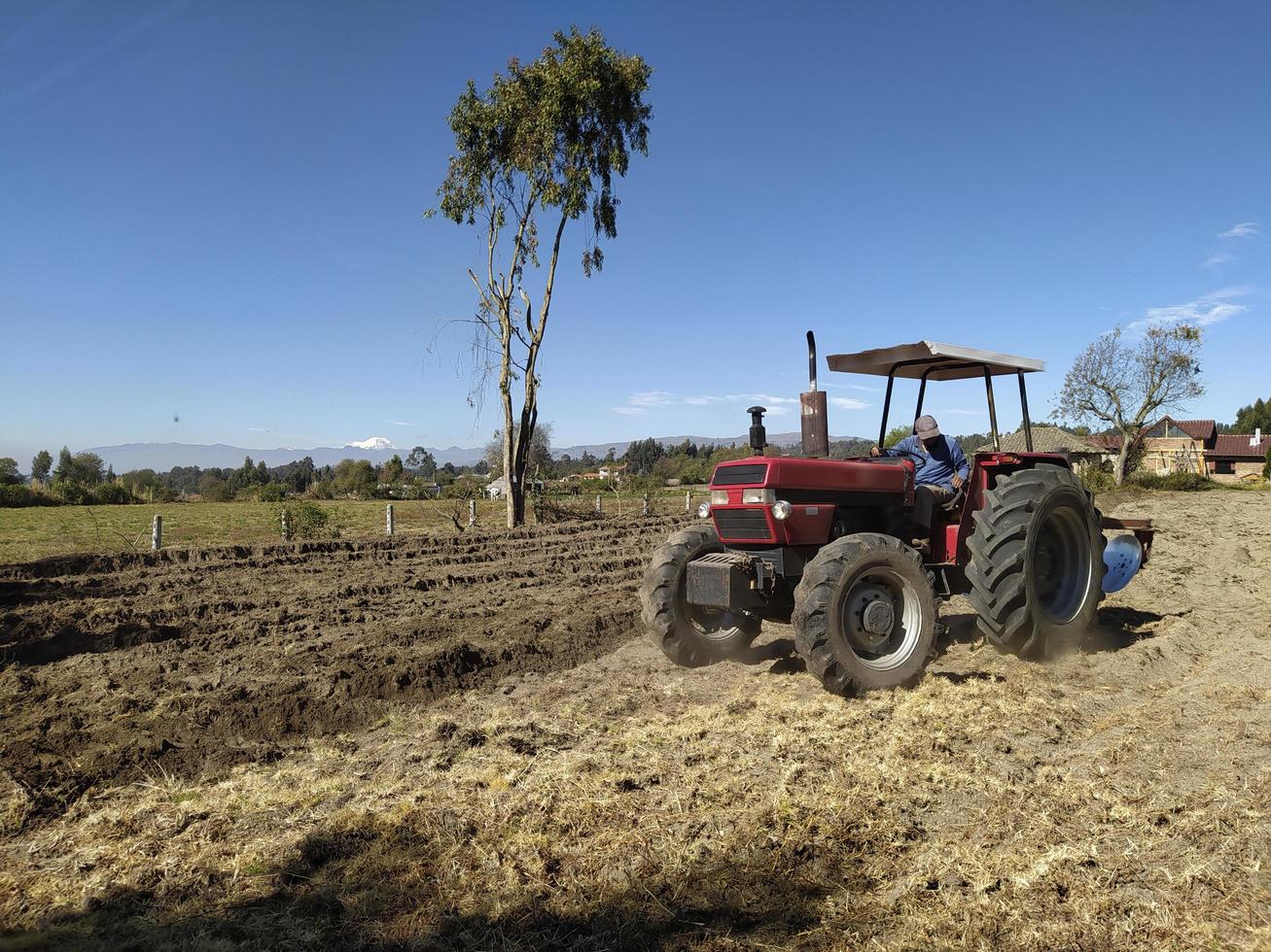 ein Traktor, der ein Feld pflügt foto