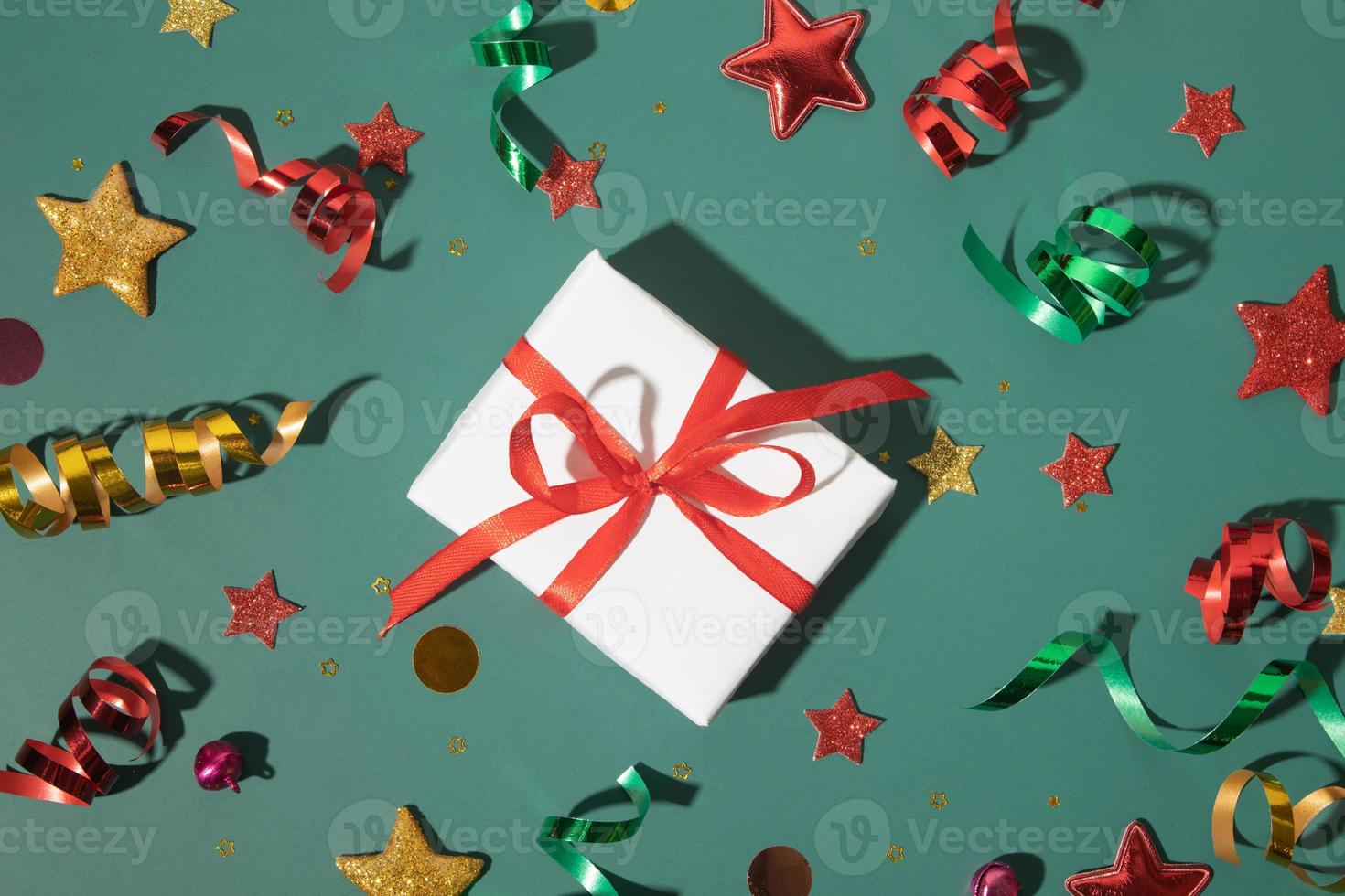 Draufsicht glänzender Hintergrund mit Geschenkbox, Sternen, Luftschlangen, Funkeln. kreative Idee für den Winterurlaub foto