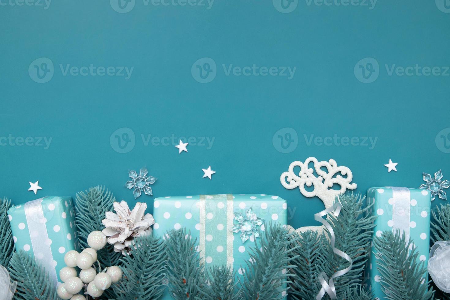 Weihnachtsflacher Hintergrund mit Geschenken, Beeren und Kiefer auf türkisfarbenem Hintergrund mit Kopierraum foto