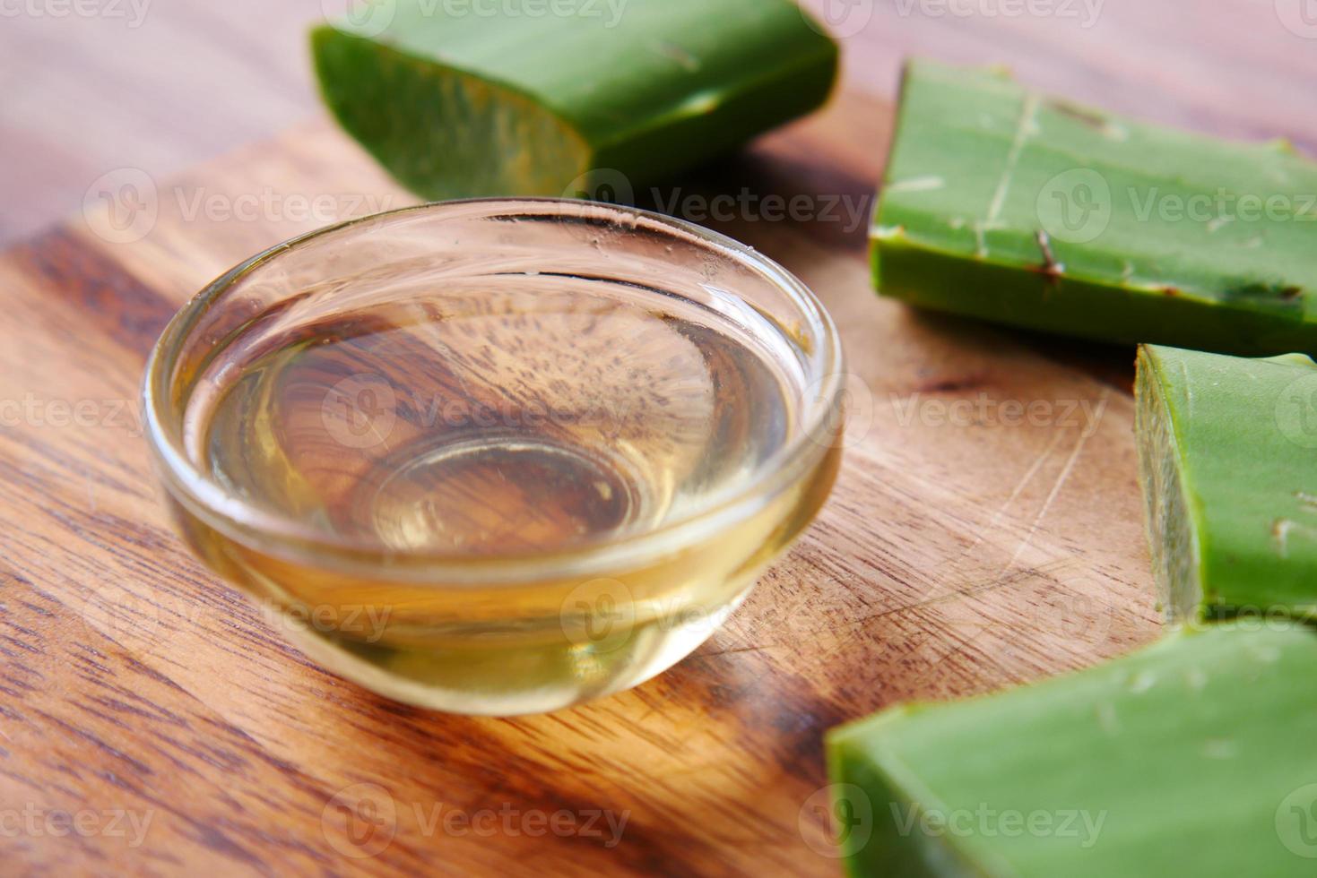 Nahaufnahme frische Aloe Vera in Scheiben geschnitten und Öl in einem Behälter auf einem Schneidebrett? foto