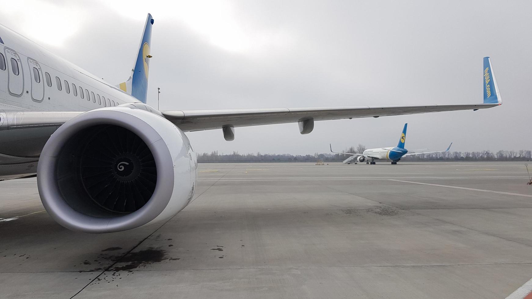 ukraine, borispol - 27. märz 2020. Triebwerksturbine und Flügel eines großen Passagierflugzeugs warten auf den Abflug am Flughafen vor dem Hintergrund des Flughafens. um die Welt reisen. foto