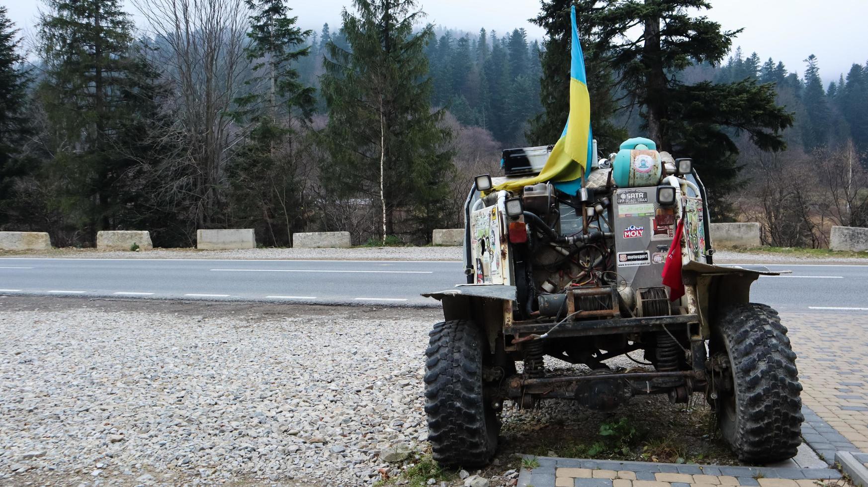 ukraine, bukovel - 20. november 2019. Buggys mit Aufklebern und einer blau-gelben Flagge auf dem Parkplatz des Ferienortes Bukovel in der Westukraine. kleines leichtes suv. foto