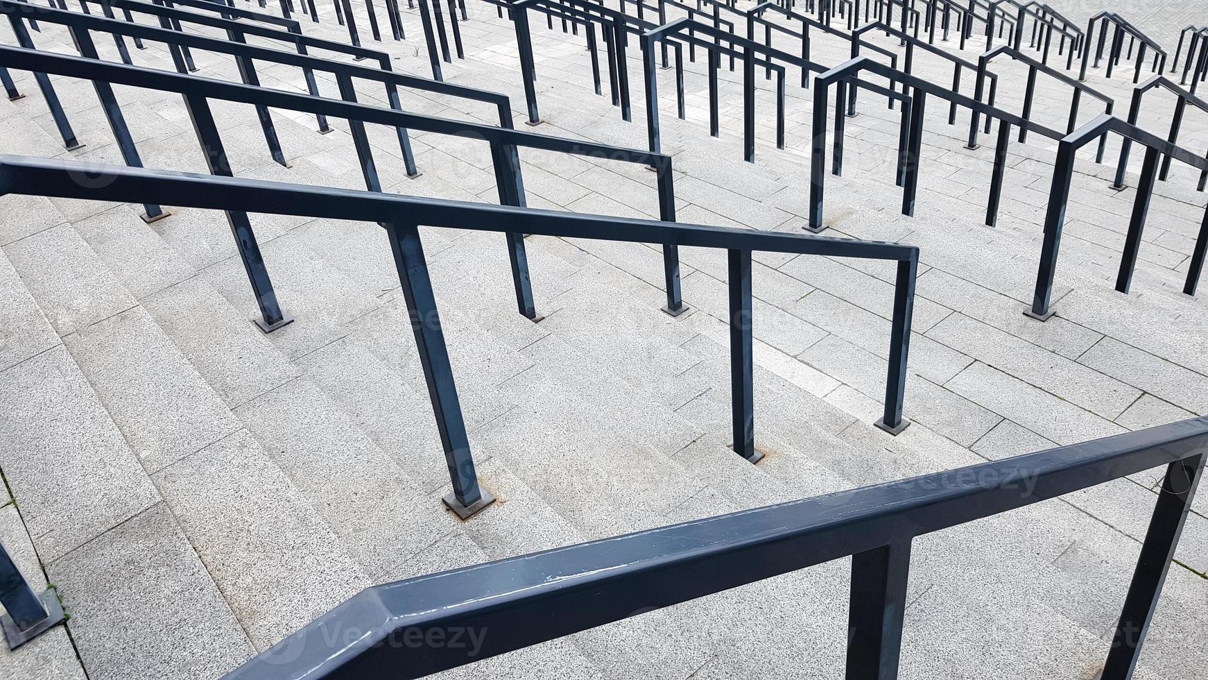 externe mehrstufige Steintreppe. Es gibt viele Treppen und Geländer aus Metall. viele Schritte in einer städtischen Umgebung, symbolischer abstrakter Hintergrund. foto