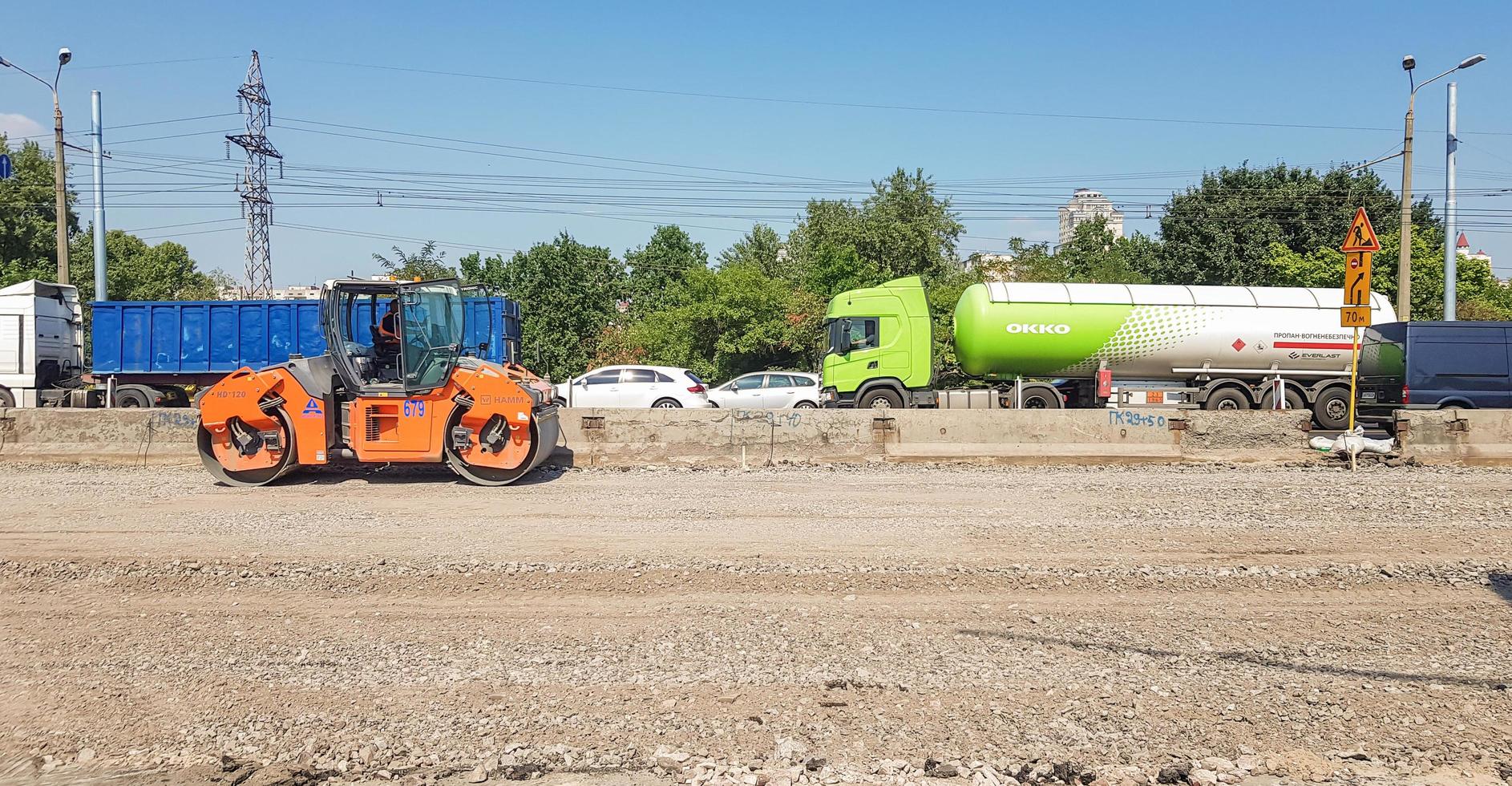 Ukraine, Kiew - 1. Oktober 2019. Straßenwalze, Traktor und Baumaschinen arbeiten an einer neuen Straßenbaustelle. die Straße ist wegen Straßenreparatur, Streckenverlängerung, Schlaglochreparatur gesperrt foto