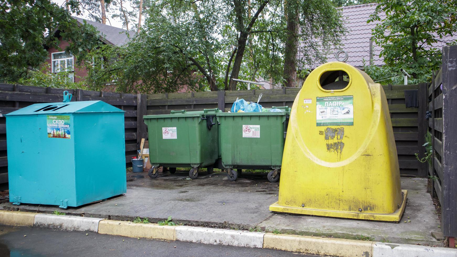 vier Mülltonnen aus Kunststoff und Metall zur Mülltrennung im Hof einer Wohnstraße. Mülleimer im Hof eines Wohnhauses. Ukraine, Kiew - 29. August 2021. foto