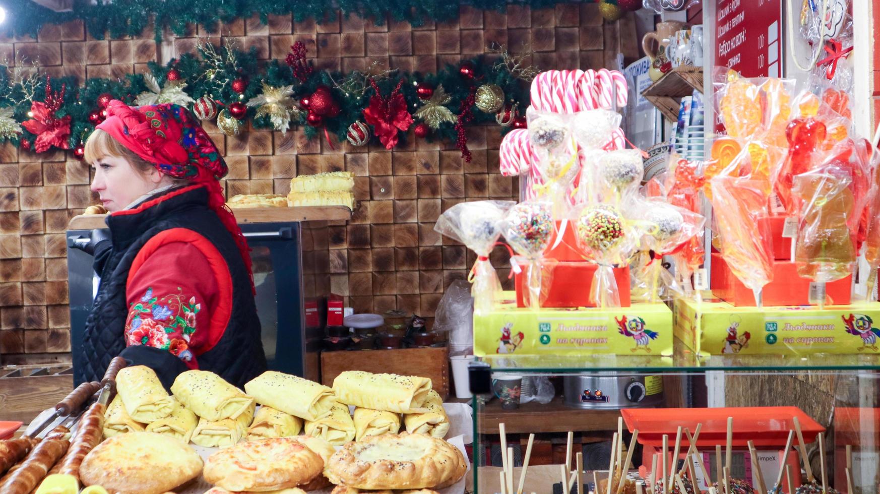 Ukraine, Kiew - 3. Januar 2019. Kioske mit Speisen und Souvenirs auf dem Weihnachtsmarkt. Verkauf von Süßigkeiten auf dem Weihnachtsmarkt, süße Weihnachtskugeln auf der Vitrine auf der Messe verkaufen foto