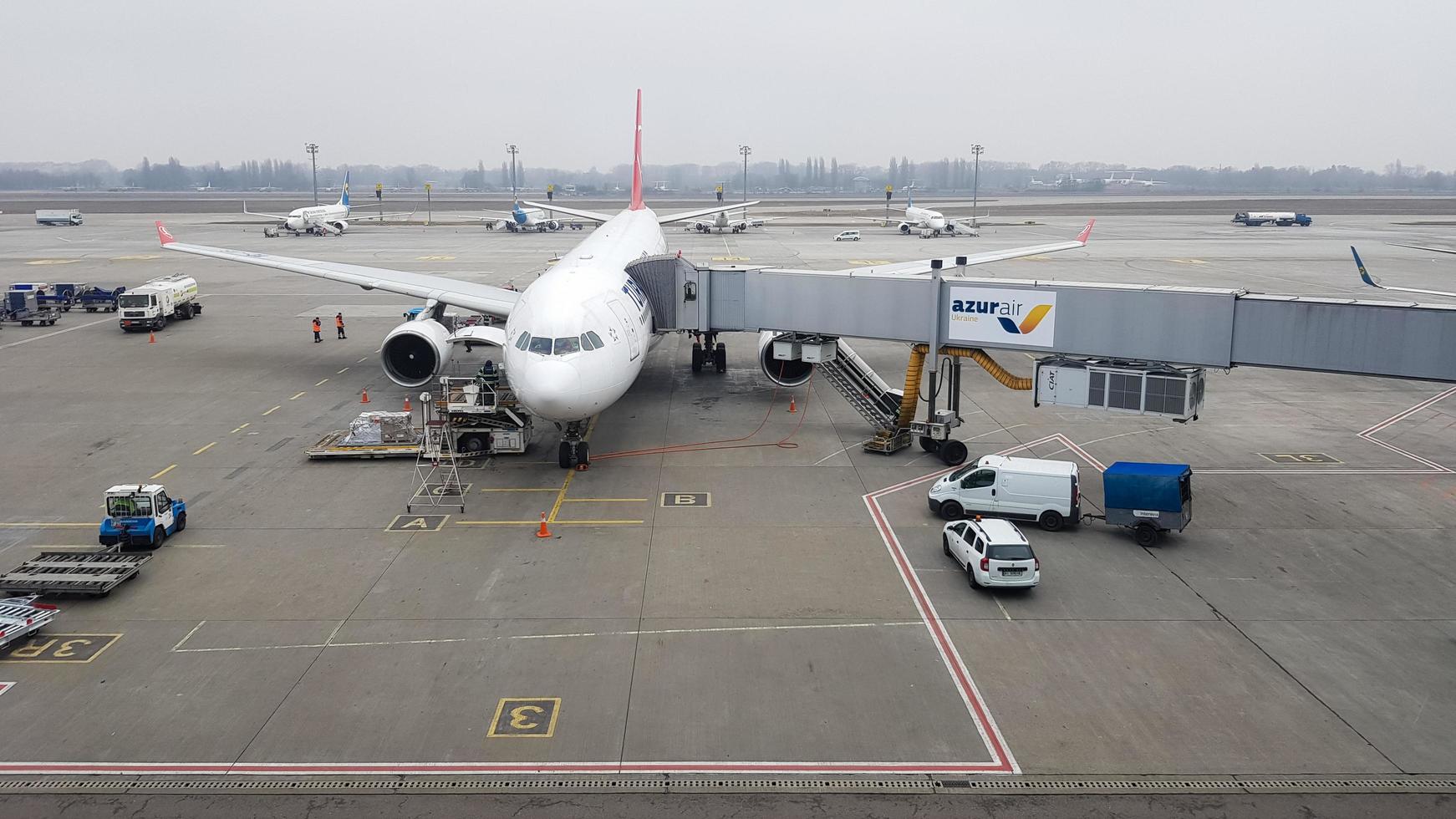 ukraine, borispol - 27. märz 2020. ein Passagierflugzeug mit einer Einstiegsleiter und einer Jet-Brücke. Warten auf Passagiere und Gepäck vor dem Einsteigen vor dem Abflug. azur air ukrainische fluggesellschaft. foto