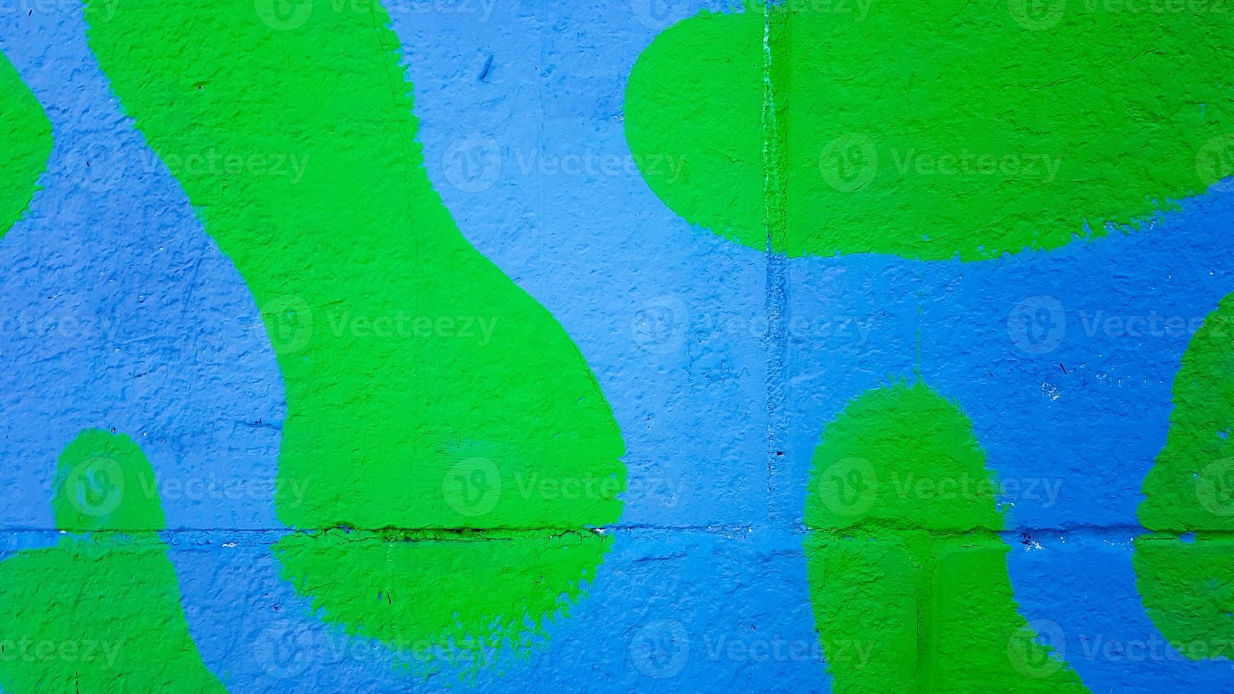 die Betonwand ist in grün-blauer Tarnfarbe gestrichen. Farbflecken auf einer Steinmauer, bunter Hintergrund mit Kopierraum. foto