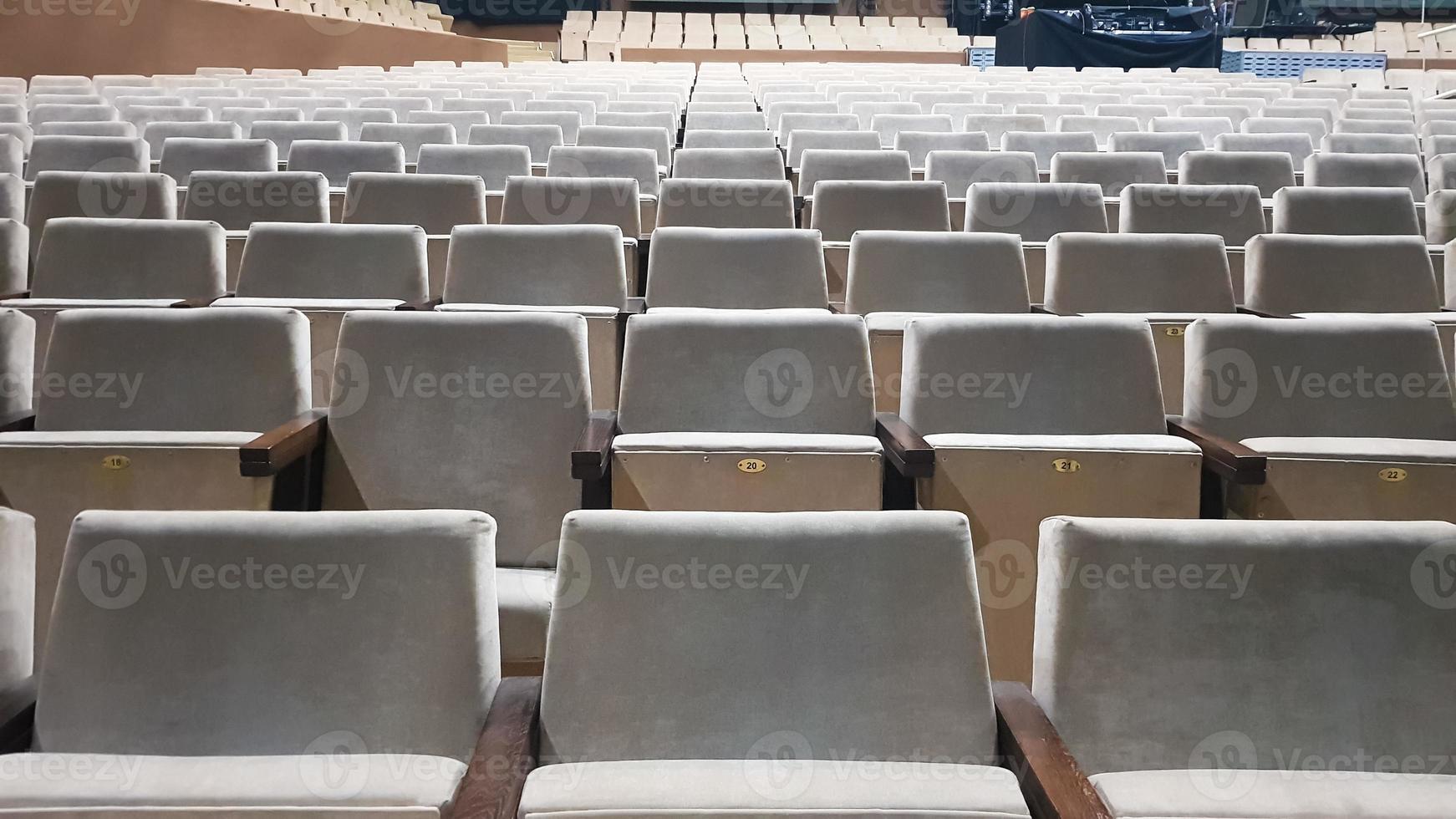 viele alte beige gepolsterte stühle ohne menschen im saal für auftritte und filme. Hintergrund von vielen Stühlen auf den Tribünen in einem Konzertsaal oder Theater. foto